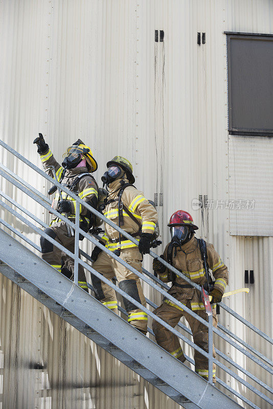 消防队员在工业大楼外爬楼梯