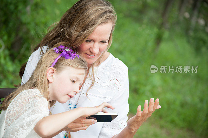 女儿正在教她妈妈如何使用电话