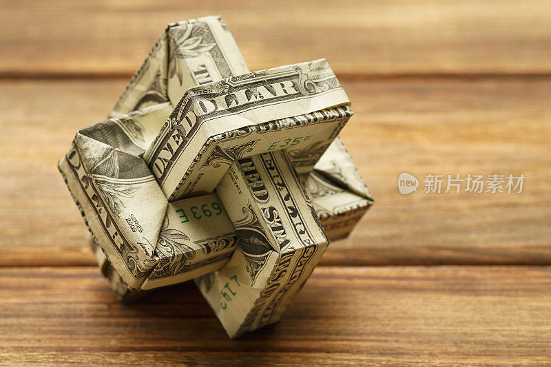折纸钱由美元在木材背景