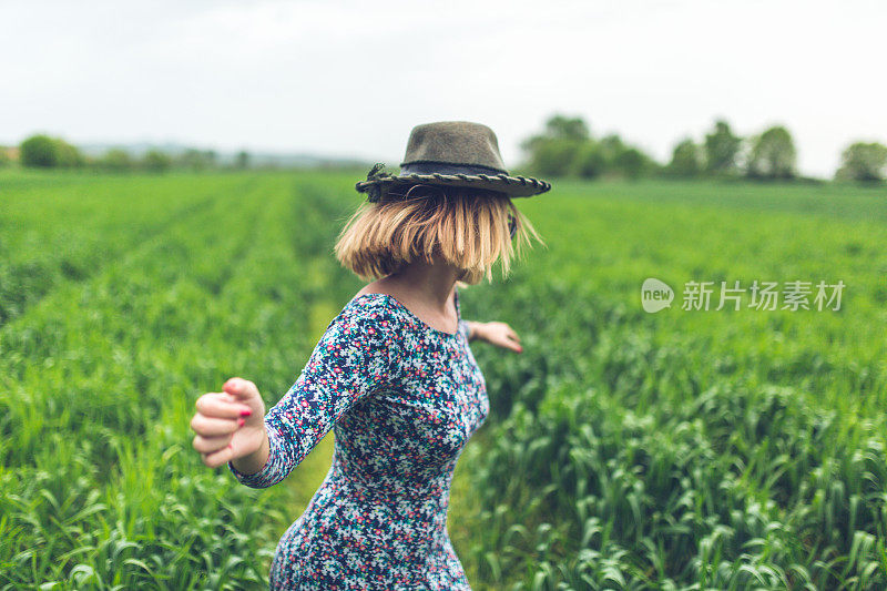 美丽的女人在田野里跳舞