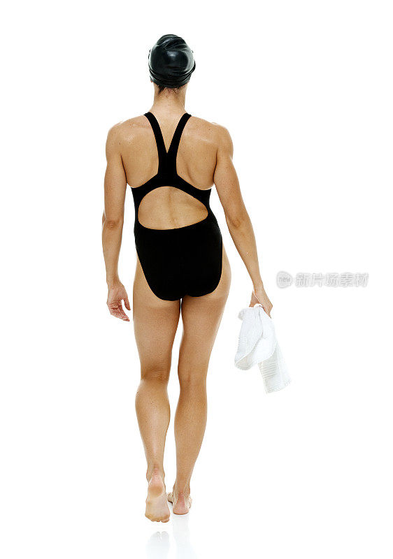 后视图的女性游泳运动员拿毛巾和行走