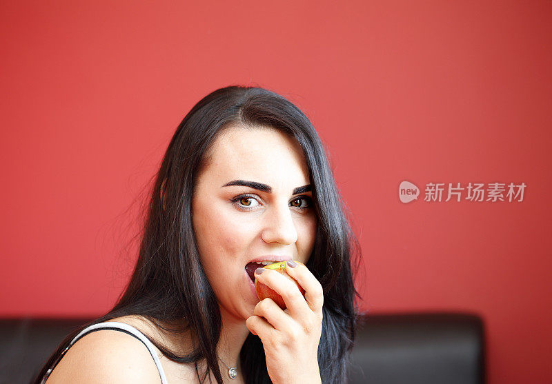年轻的成年女性正在吃苹果
