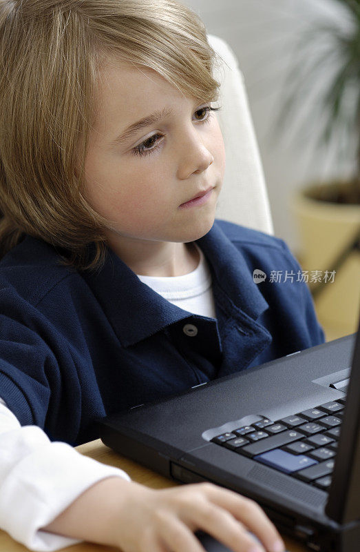 专心致志的小男孩和笔记本电脑