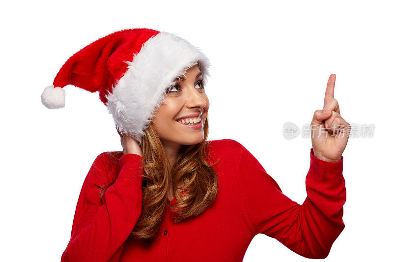 漂亮的年轻女子戴着圣诞老人帽指着文案