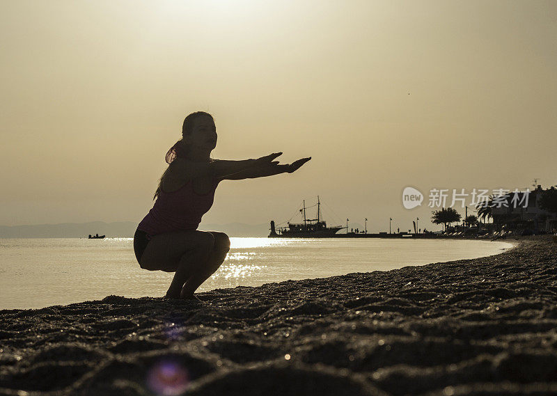 年轻女性在沙滩上锻炼