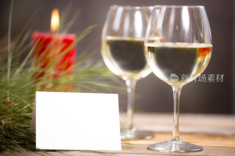 白葡萄酒，杯子，松枝，便条卡。蜡烛。假日优雅。