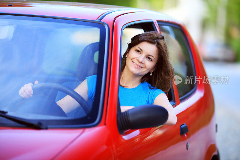 漂亮的黑发女人开着车。