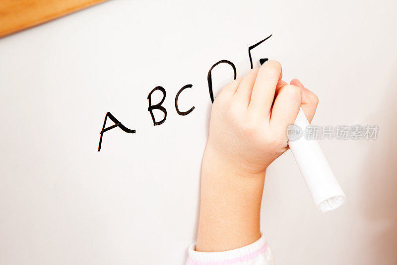 孩子在白板上写字母