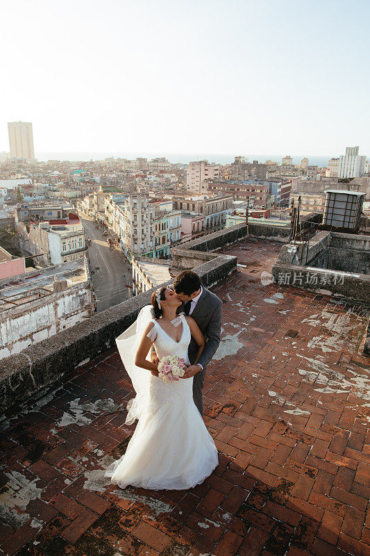 美丽的西班牙新婚夫妇在屋顶接吻