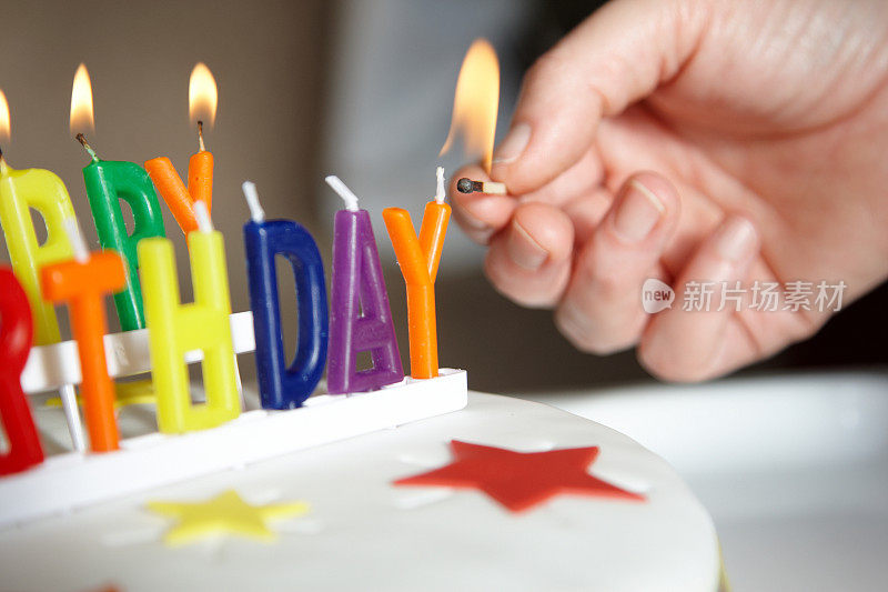 女人在生日蛋糕上点蜡烛