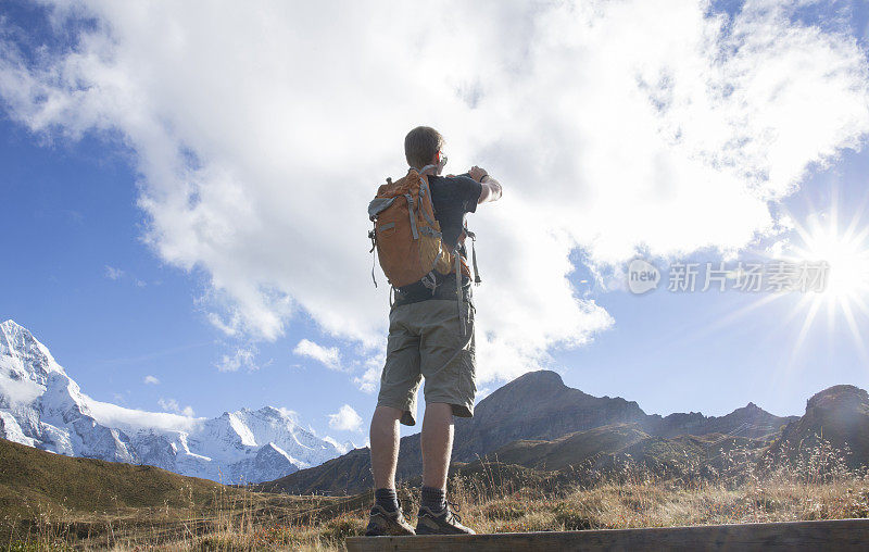 一个徒步旅行者用智能手机拍下了山的照片