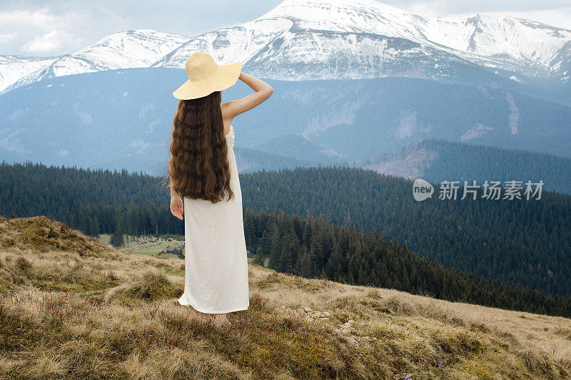 年轻女子站在山的山坡上