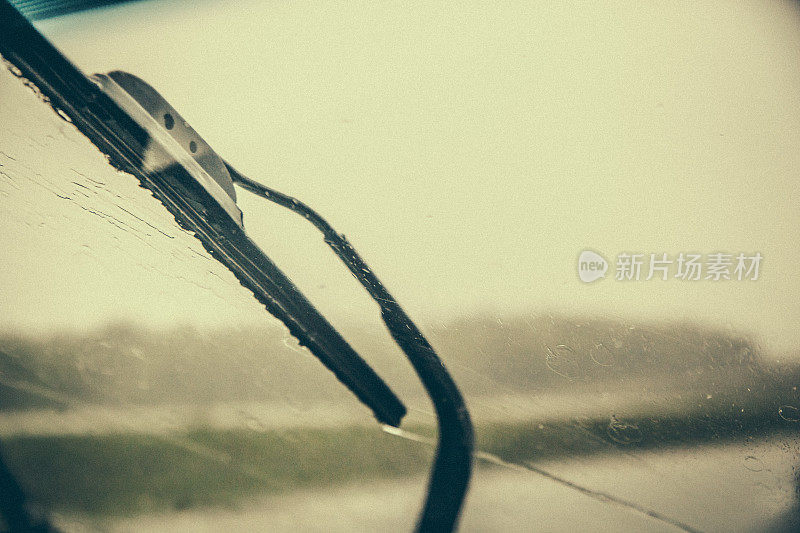 在一个非常下雨的日子里，在新布伦瑞克的道路上驾驶的一个挡风玻璃刮水器的特写。