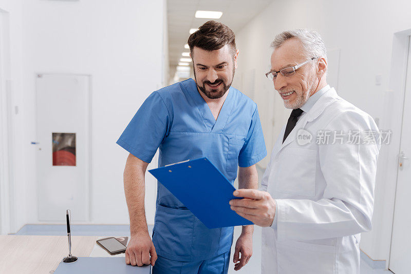 微笑的老年儿科医生喜欢在工作时与同事交谈