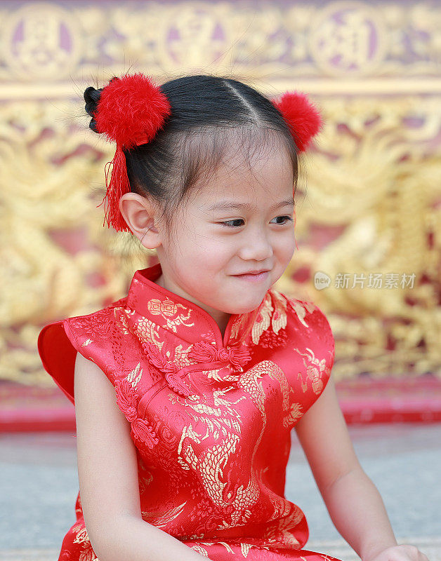 微笑的亚洲小女孩穿着旗袍在中国传统新年节日。