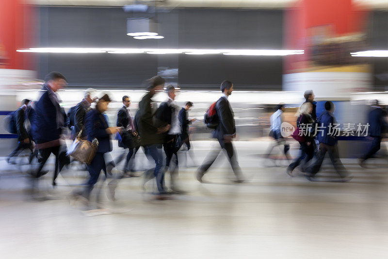 伦敦地铁站里，一群人的运动模糊了步行的商人