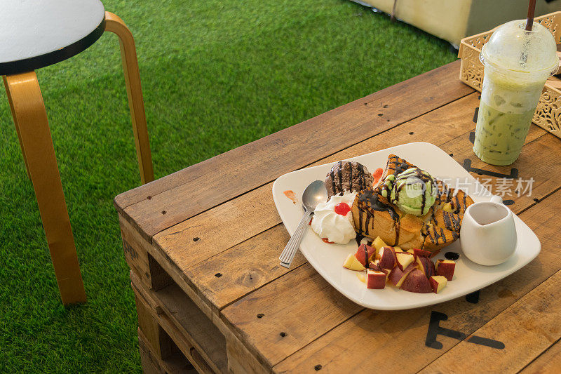冰淇淋配面包和苹果片放在桌上的木头上