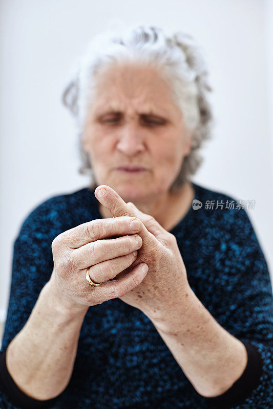 老年妇女揉她的手指患风湿