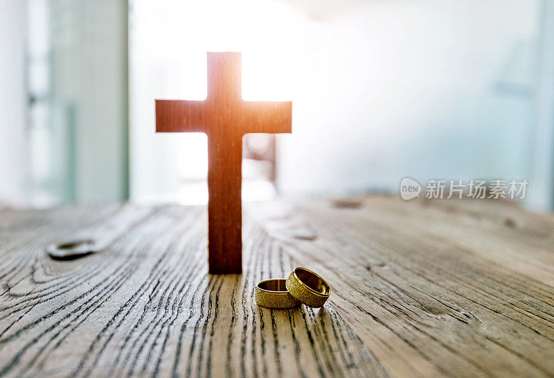 婚戒和十字架放在桌上