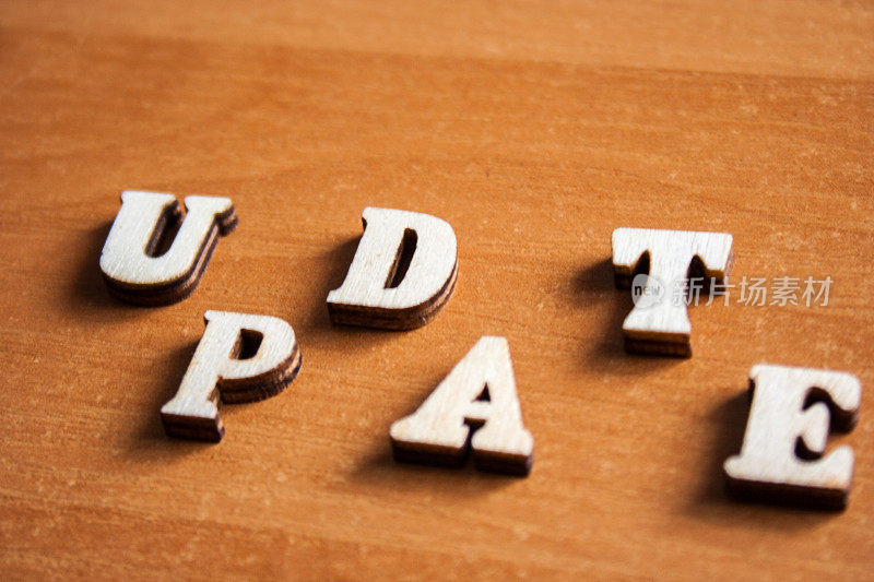 “update”这个词是由木制字母组成的。木头铭文