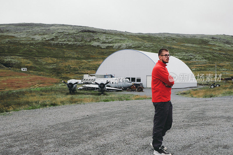 在冰岛，戴眼镜的人呆在废弃的农场和废弃的旧飞机附近
