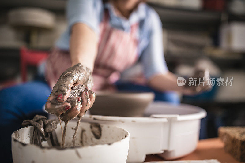 在艺术工作室里，年轻的妇女们在陶轮上制作陶器。