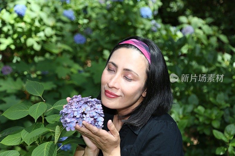 女人在闻绣球花。