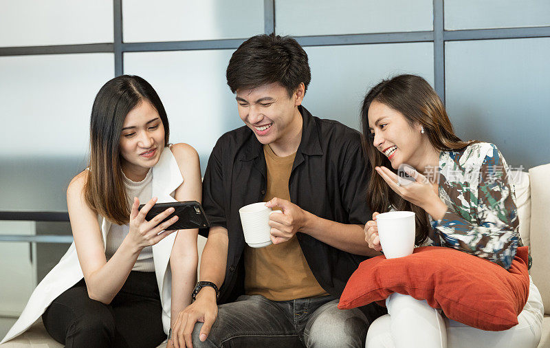 一群自信的年轻亚洲人与朋友们畅谈快乐，喝咖啡