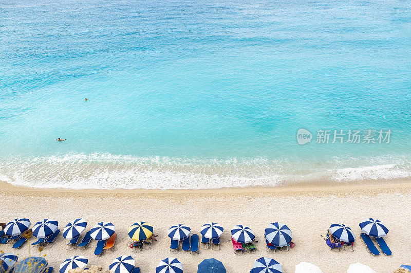 海滩伞和蓝色的大海。从上面看到的海滩景色。