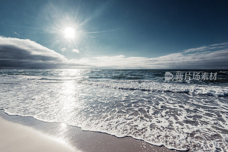 海滩上的波浪被太阳照得闪闪发光