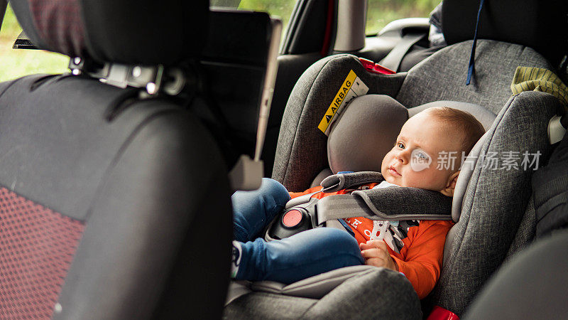 为了安全，孩子坐在汽车座位上。