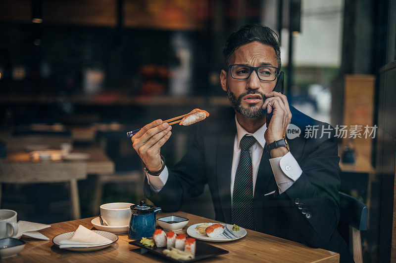 在寿司店打电话的男人