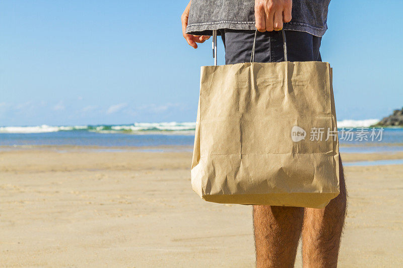 在天堂般的海滩上，一个顾客拿着包。