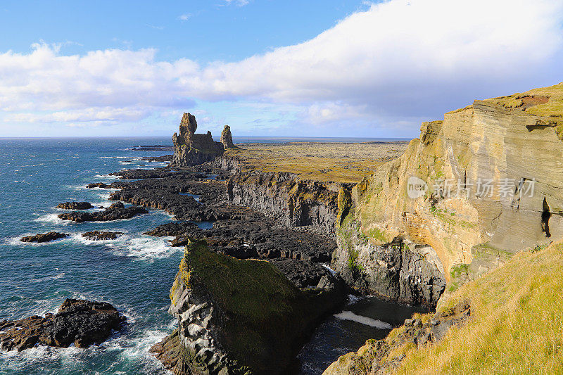 冰岛西部Snaefellsnes半岛南海岸的海岸线和Londrangar玄武岩悬崖上的岩石和熔岩形成。隆德兰加玄武岩悬崖，巨大的熔岩塔。