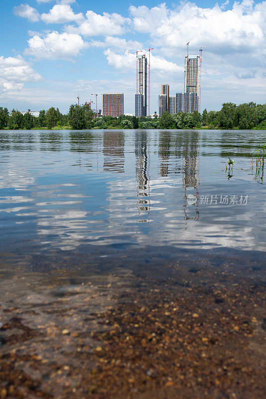 附近建有高大的建筑，美丽的公园和河流，低角度视野直接从水面