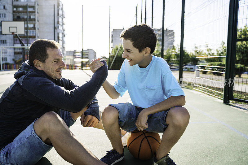 上午的训练。父亲和儿子打篮球。父亲和儿子之间的对话