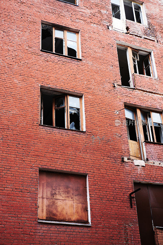 废弃的红砖多层住宅，窗户被破坏的大气摄影