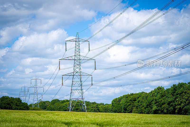 塔式电力电力配电架空电缆穿过蓝天白云的农村农田