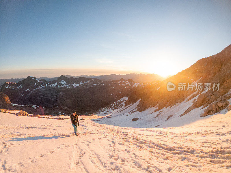 女登山者在雪道上攀登山峰