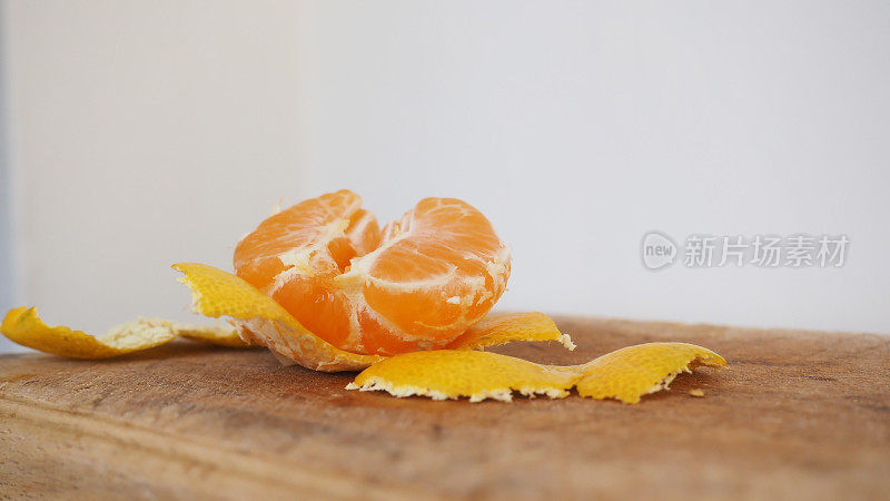 厨房里的一块木板上，放着半个剥了皮、多汁的黄橘子