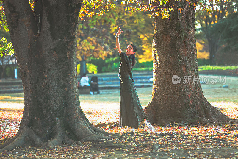 美丽的女子在秋天的森林里跳舞