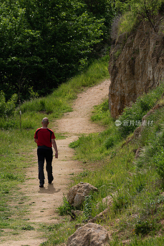 中年男子走在自然环境中，徒步路线