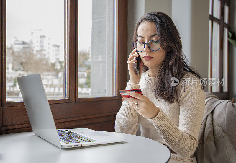 年轻女子用信用卡在电脑上购物