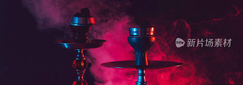 水烟碗，水烟和煤在烟熏黑色背景与彩色照明。横宽照片字幕，封面。copy-space