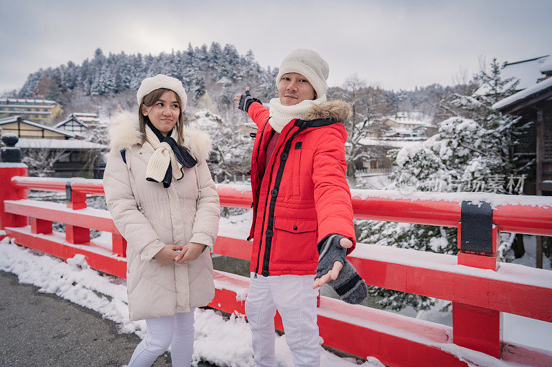 情侣们在大雪纷飞的冬天享受日本之旅。