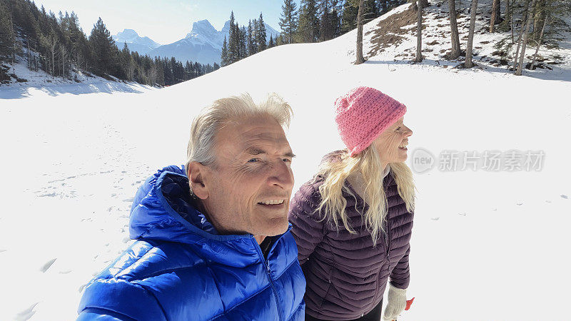 成熟的夫妇走在雪山小路上