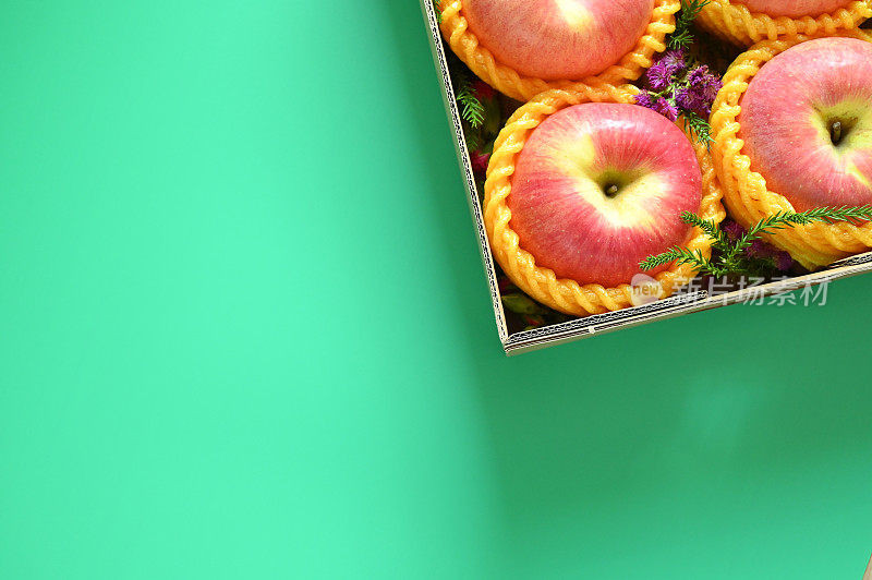绿色背景的盒子里有漂亮的粉色苹果