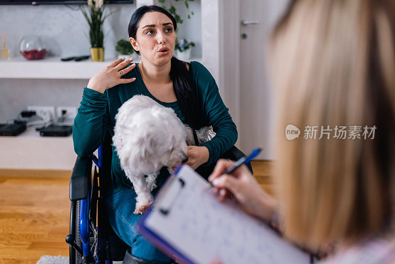 坐在轮椅上的年轻女子与她的治疗犬和心理治疗师找到了一个养育空间