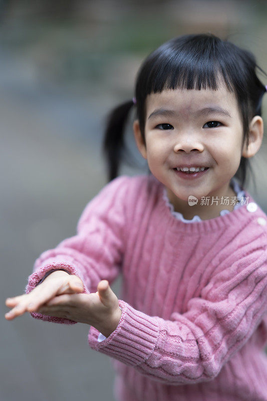 可爱的亚洲小女孩，儿童肖像照片，在公园里快乐地玩耍