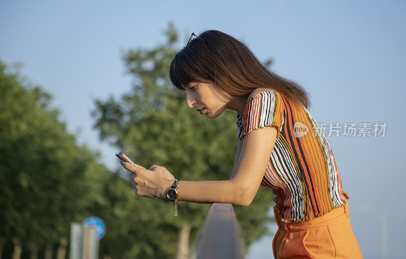年轻女子在街上玩手机